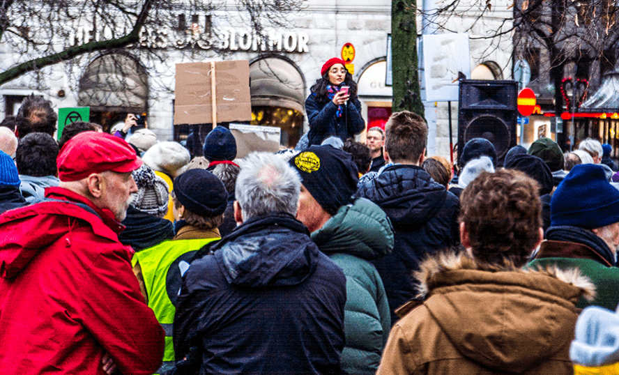 Foto på personer som står utomhus och demonstrerar