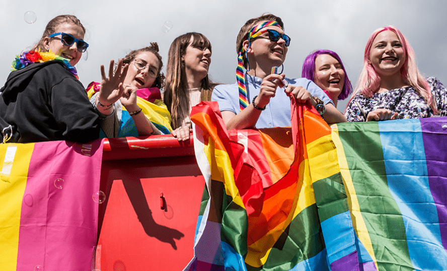 Ungdomar med prideflagga.