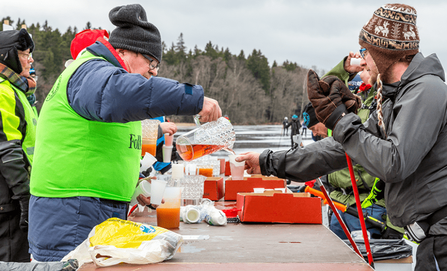 Volontärer som delar ut dricka till tävlingsdeltagare.