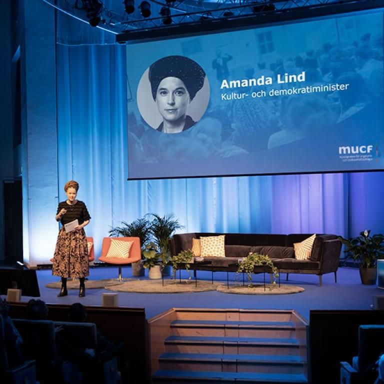 Kultur- och demokratiminister Amanda Lind håller ett anförande från scen på MUCF:s rikskonferens 2019.