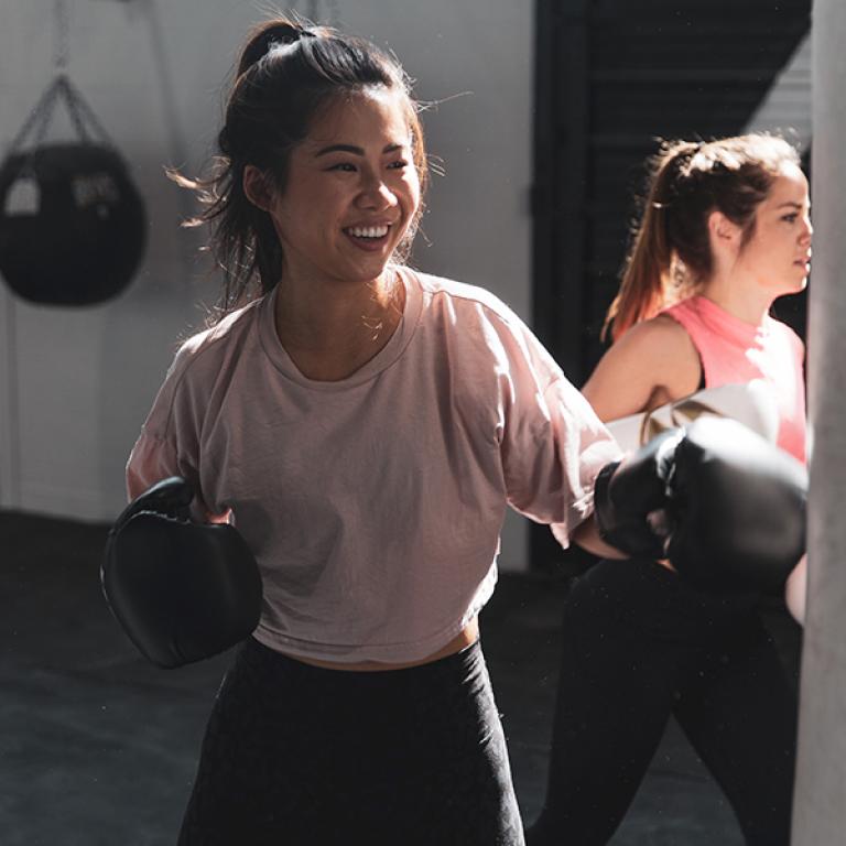 Bild på två unga kvinnor som tränar boxning. Fotograf: Logan Weaver