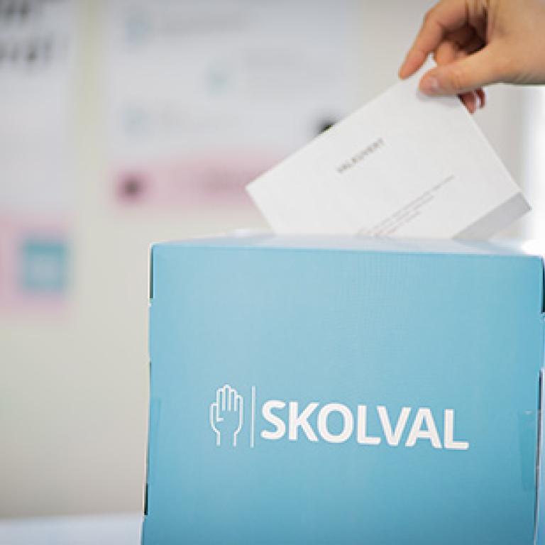 Bild på hand som lägger ner valsedel i valurna för EU skolval 2024