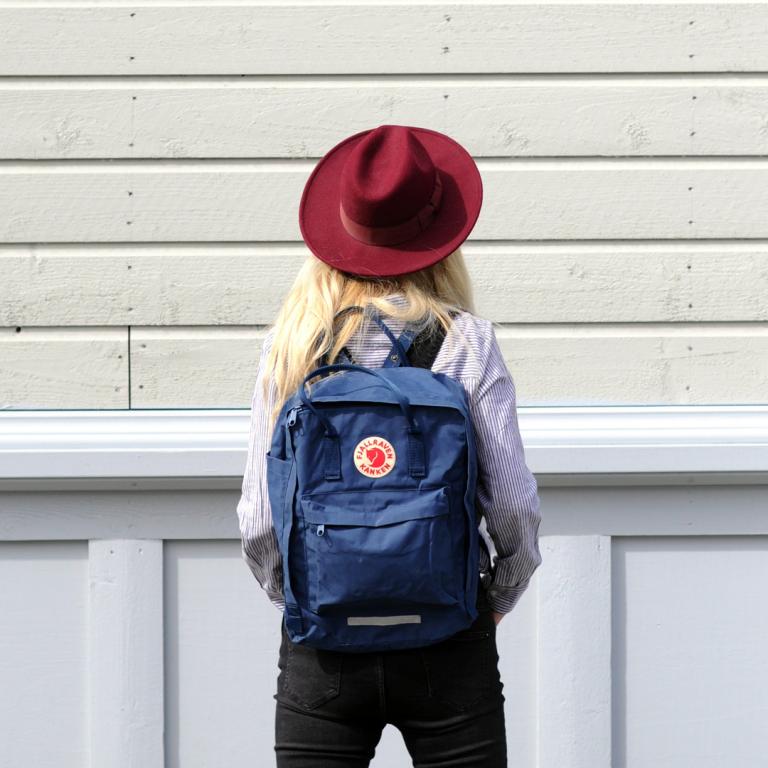 Tjej med hatt och ryggsäck