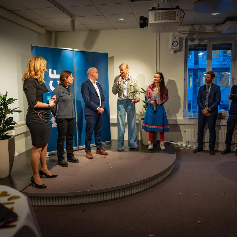 Bild från lokalen där Morgon på MUCF hålls. Bild från invigningen med personer på en scen.