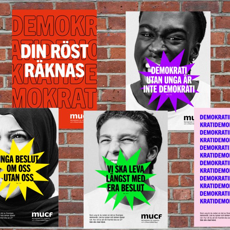 Bild på affischer med ansikten mot en tegelvägg